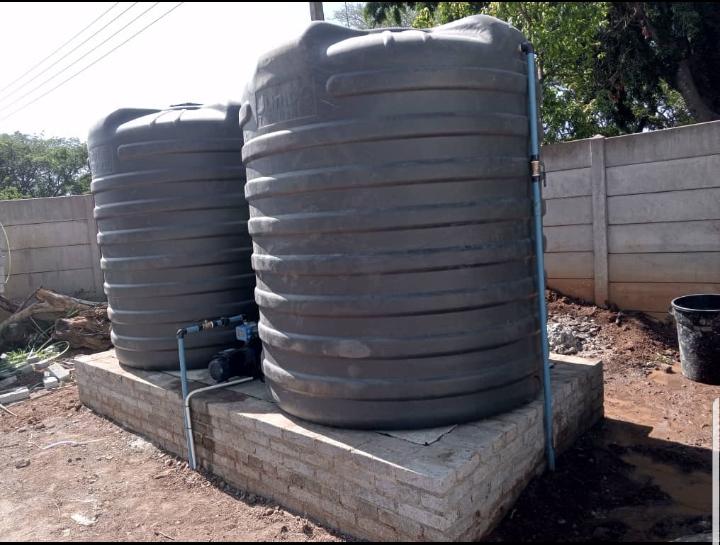 Water storage tanks with pump on brick platform